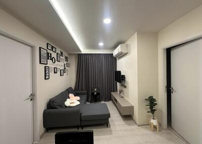 Modern living room with gray sofa, wall decorations, and air conditioning