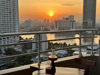 Sunset view from balcony with city skyline and river