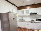 Modern kitchen with wooden flooring and white cabinets