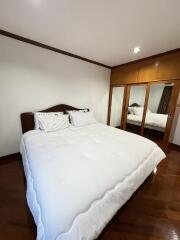 A cozy bedroom with a double bed and built-in mirrored wardrobe