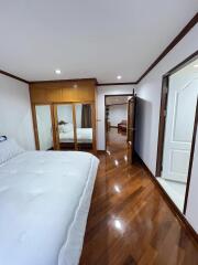 Spacious bedroom with wooden flooring and large mirrored closet doors