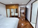 Spacious bedroom with wooden flooring and large mirrored closet doors