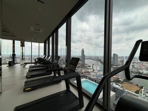 Modern gym with city view, featuring multiple treadmills and large windows