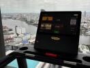 Modern living area with a stunning city view featuring a treadmill desk setup