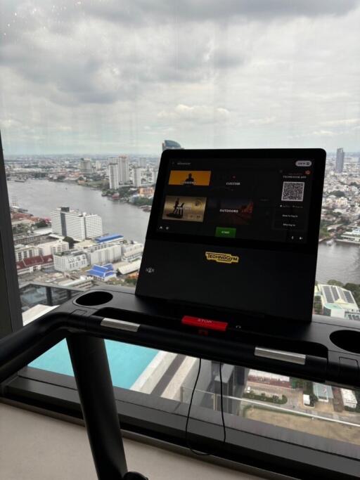 Modern living area with a stunning city view featuring a treadmill desk setup