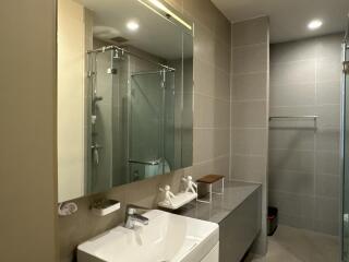 Modern bathroom with a glass shower, large mirror, and a sink