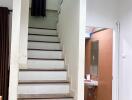 Indoor staircase with partial view of bathroom