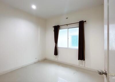 Empty bedroom with window and brown curtains