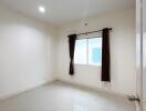 Empty bedroom with window and brown curtains