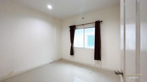 Empty bedroom with window and brown curtains