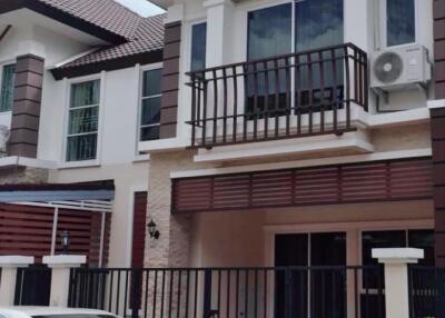 Exterior view of a two-story residential building with a gated driveway