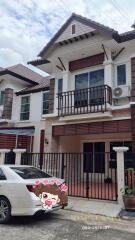 Exterior view of a two-story residential building with a gated driveway