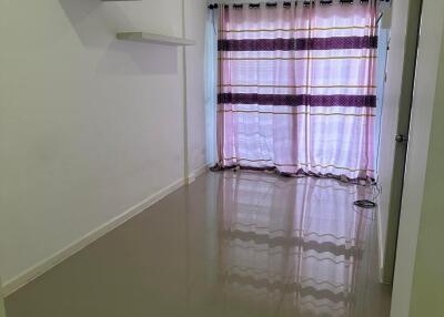 Living room with tiled floor, curtain, and wall shelves