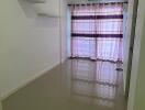 Living room with tiled floor, curtain, and wall shelves