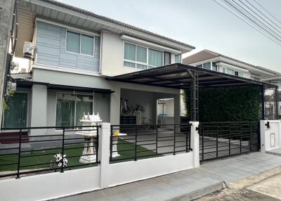 Exterior view of a modern two-story house with a covered parking area