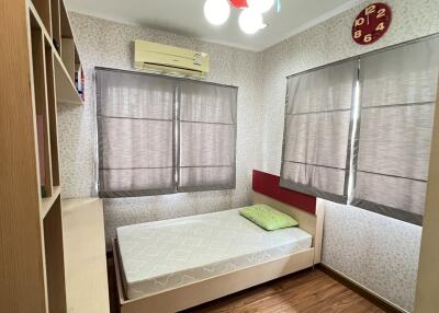 Small bedroom with a single bed, bookshelf, and air conditioning