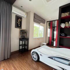 Bedroom with modern decor and unique car-shaped bed