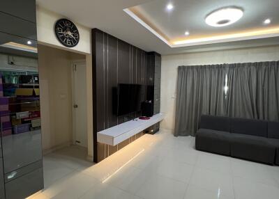 Modern living room with gray sofa, floating TV unit, and recessed lighting