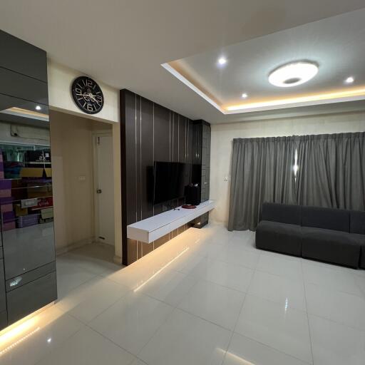 Modern living room with gray sofa, floating TV unit, and recessed lighting