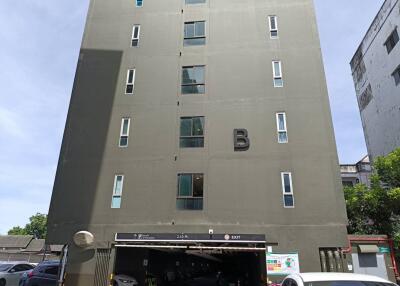 Exterior of a multi-story residential building with parking area at the ground floor