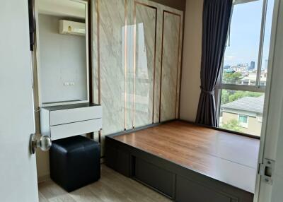 Bedroom with a raised platform bed and dresser with mirror