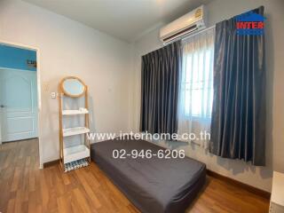 Simple bedroom with a mattress on the floor, a shelf with a mirror, and an air conditioner.