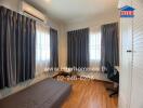 Bedroom with wooden flooring, window drapes, air conditioning, and a desk.