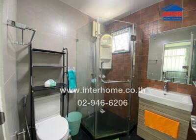 Modern bathroom with glass shower enclosure and wall-mounted sink.