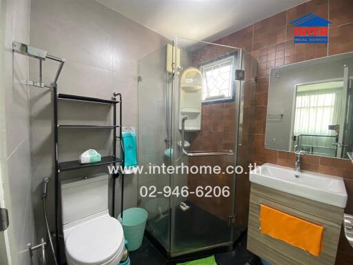 Modern bathroom with glass shower enclosure and wall-mounted sink.