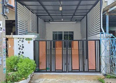 Front view of a house with a covered parking area and gate