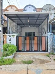 Front view of a house with a covered parking area and gate