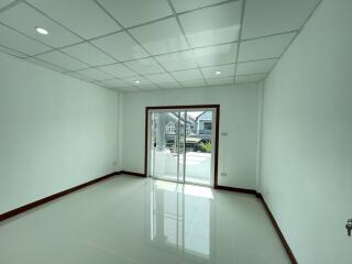 Empty room with tiled floor and sliding glass doors leading to a balcony