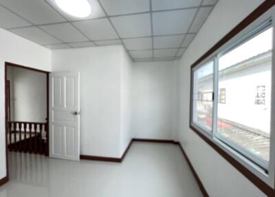 Empty bedroom with a window and wooden door