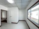 Empty bedroom with a window and wooden door