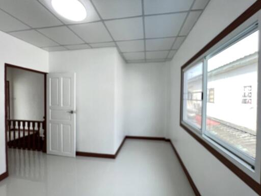 Empty bedroom with a window and wooden door