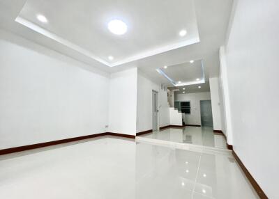 Spacious living room with bright white walls and tiled floors