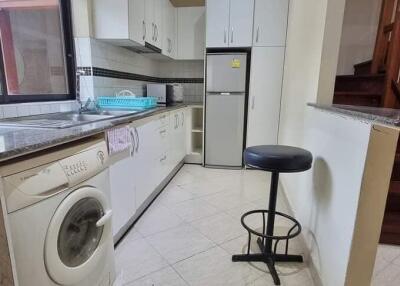 Modern kitchen with appliances and staircase in the background