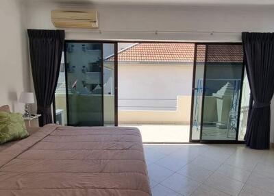 Spacious bedroom with large sliding doors leading to a balcony