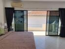 Spacious bedroom with large sliding doors leading to a balcony