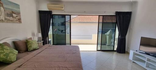 Spacious bedroom with large sliding doors leading to a balcony