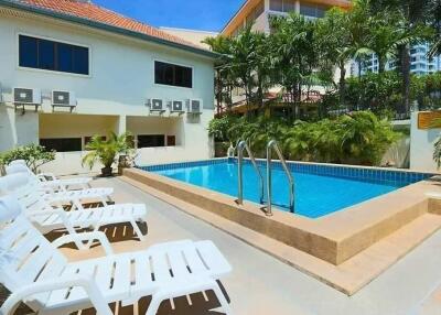 Outdoor swimming pool with lounge chairs and surrounding greenery