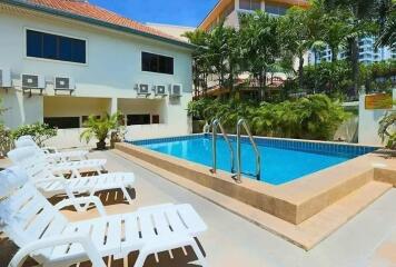 Outdoor swimming pool with lounge chairs and surrounding greenery