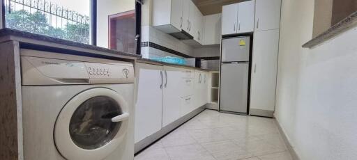 Modern kitchen with washer and stainless steel appliances