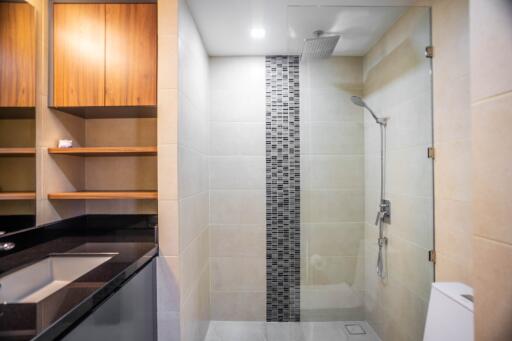 Modern bathroom with shower, sink, and storage cabinets