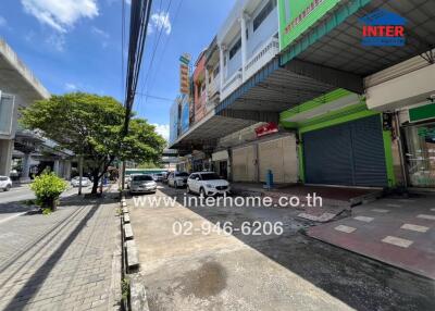 Street view of commercial buildings with contact information