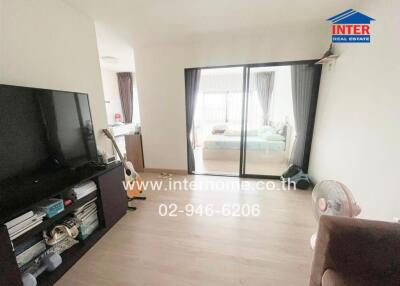 Bright living room with sliding glass doors leading to a bedroom