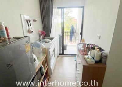 Compact kitchen with appliances and balcony view