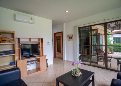 Living room with TV, bookshelves, sliding door to patio