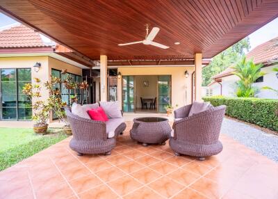 Outdoor patio with wicker furniture and ceiling fan