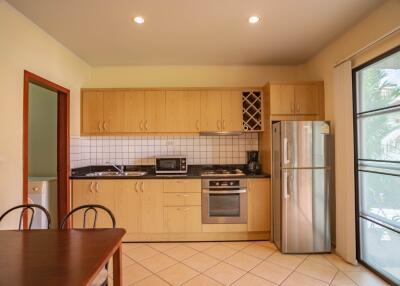 Modern kitchen with light wood cabinets and stainless steel appliances